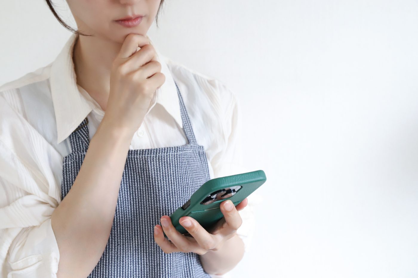 スマホを見ながら考え込むお店の方